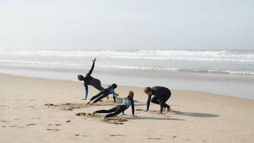 Men and Children Stretching on the Beach