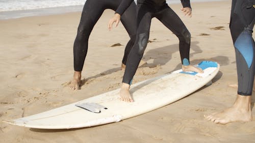 Men Teaching a Girl to Surf