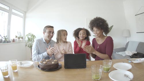 A Happy Family Singing and Clapping in front of a Tablet