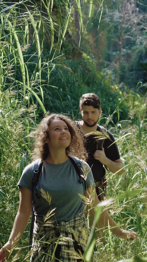 A Young Couple Walking through a Dense Forest 