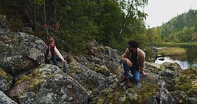 couple at rocky shore of a mountain river