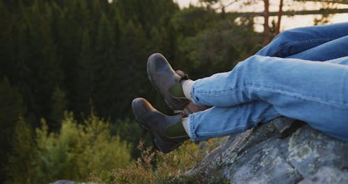 Crop People sitting on Rock