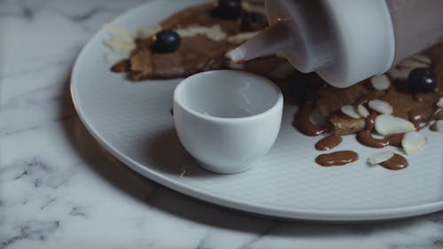 Person Putting Chocolate Syrup in the Ramekin