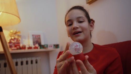 A Girl Holding a Tiny Snow Globe