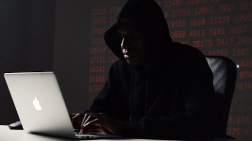 A Man Hacking on a Laptop