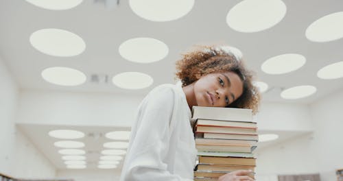 Bir Yığın Kitap üzerinde Başını Dinlendiren Bir Kadın