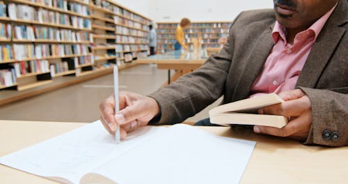 A Man Doing A Research In The Library