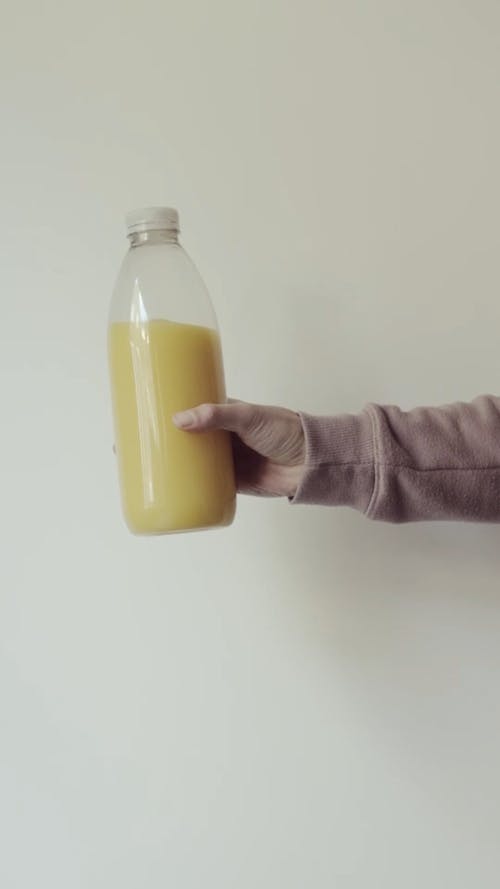 A Person Holding A Bottle of Mango Juice