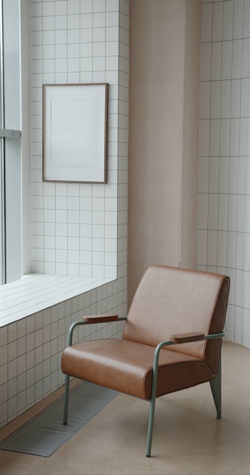 Chair Placed Next to Blank Photo Frame on Wall