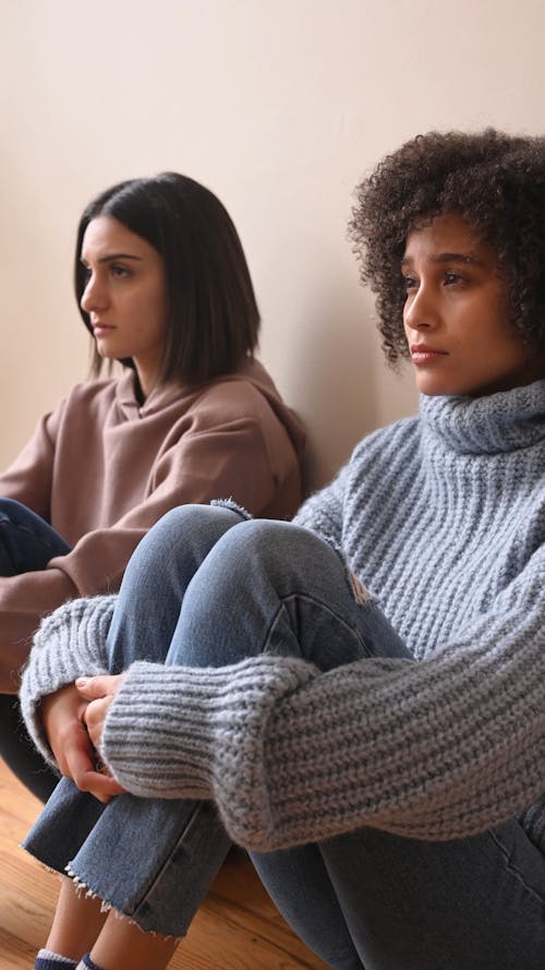 Two sad Girls Sitting on the Floor