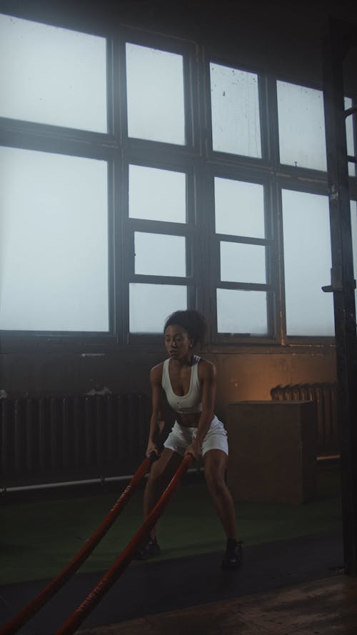 A Woman Exercising Using Battle Ropes
