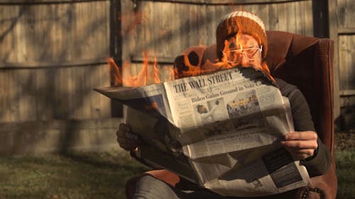 A Person Reading a Burning News Paper