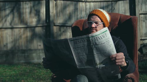 A Man Reading a Burning News Paper