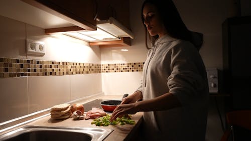 Woman Slicing the Ingredients in the Kitchen