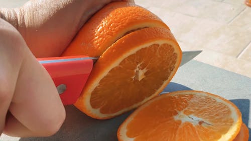 A Person Slicing the Orange