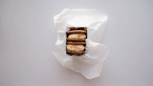 A Person Sprinkling Chocolates on a Cookie Sandwich