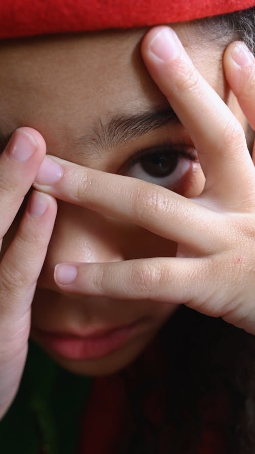 Close Up of Little Girl Peeking Through Fingers