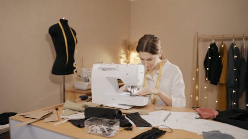 A Woman Sewing a Fabric