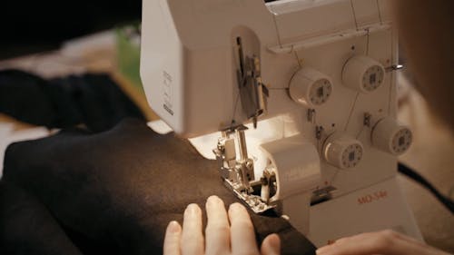 A Woman Stitching the Hem of a Cloth with a Sewing Machine