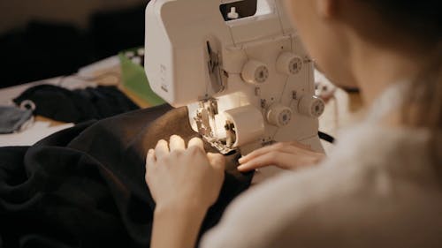 A Woman Stitching a Cloth with a Sewing Machine