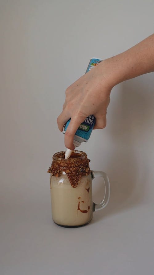 Hands Decorating Drink in Mason Jar