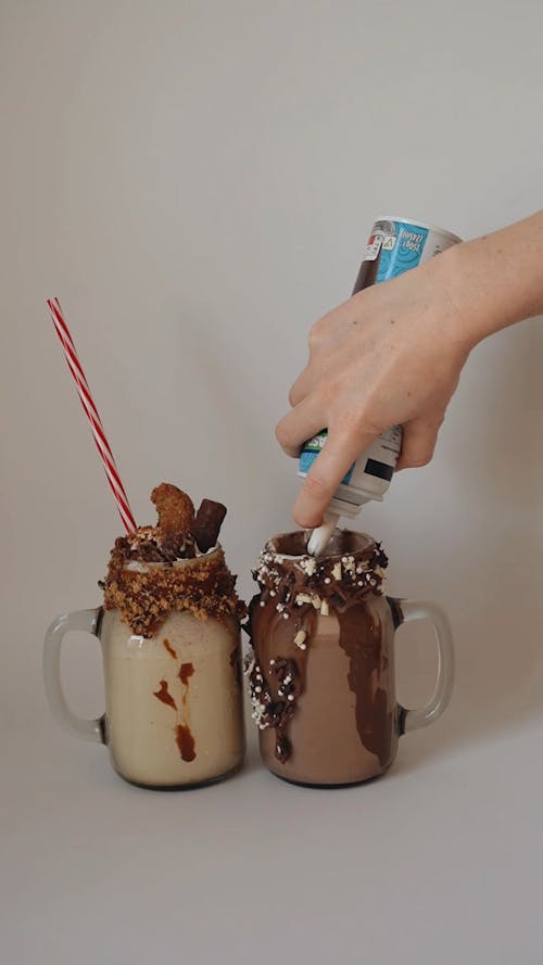 A Person Putting Whipped Cream on the Chocolate Shake