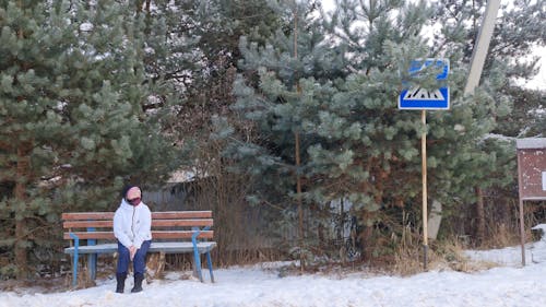 Person Sitting on a Bench on a Snowy Day