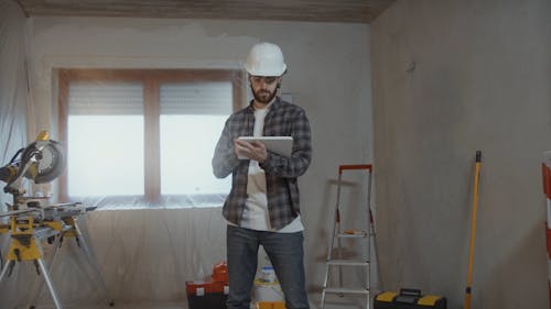 Man Renovating Home and Using Tablet