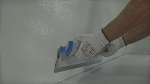 Man Smoothening Walls for Painting