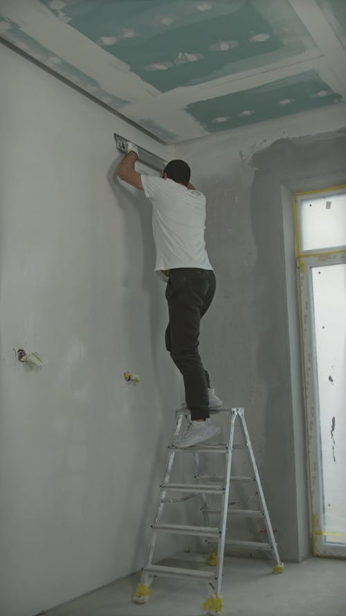 Worker Making Walls Smooth with Putty