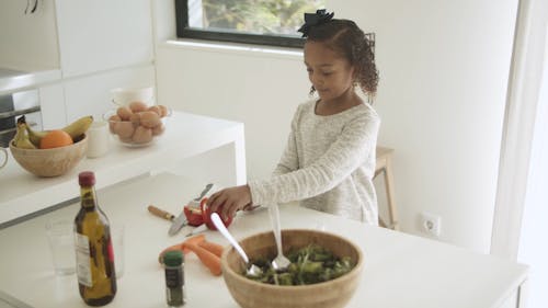 A Kid Cutting a Bell Pepper