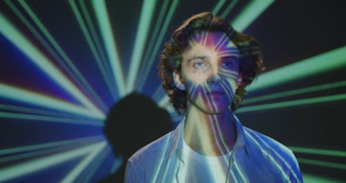 Young Man Posing with Colorful Projection on Face