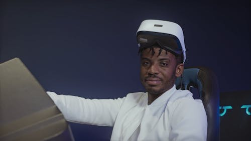 A Man Looking at the Camera While Sitting on a Simulator