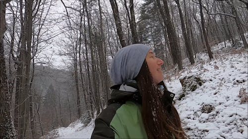 Woman Hiking in the Woods while Snowing