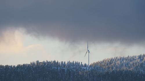 Timelapse of a Wind Turbine in a Snowy Mountain