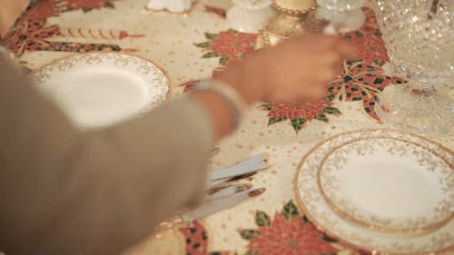A Woman Setting up a Christmas Dinner Table 