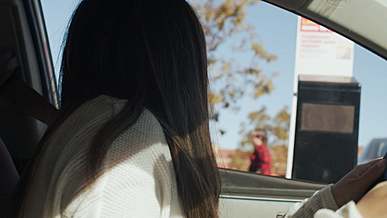 woman ordering food in a drive thru