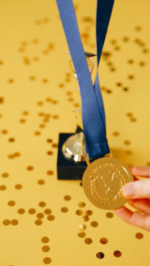 Person Placing Medal With Trophy