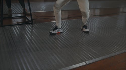 Two Athletes Practicing Fencing Indoor