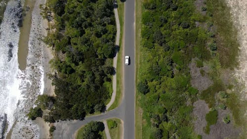 Drone Footage of Running White Car in the Middle of the Road