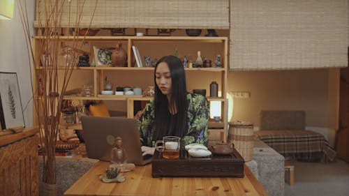 Woman Drinking Tea While Using Laptop