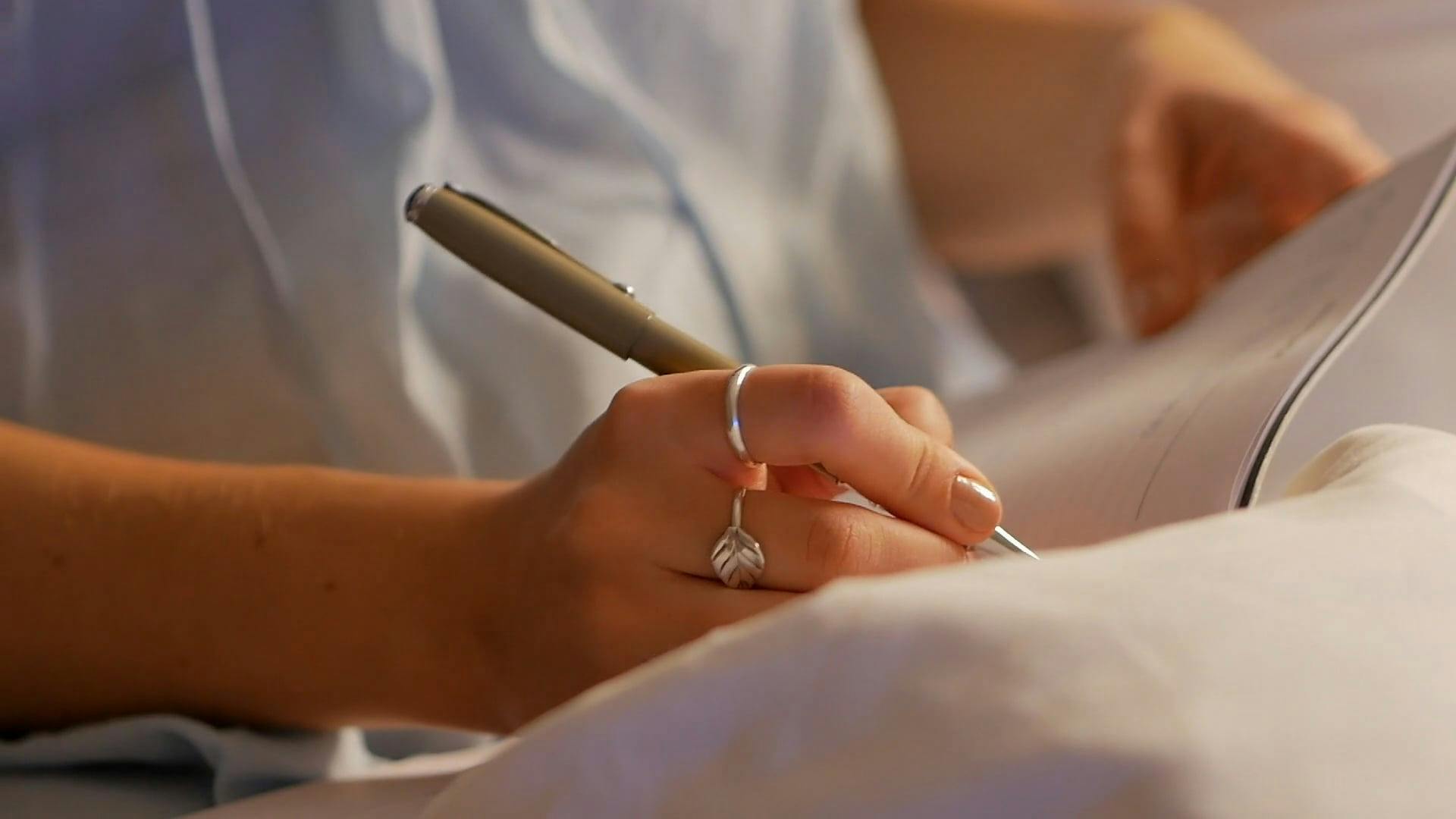 Person Writing on Notebook · Free Stock Video