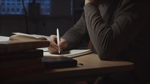 A Man Using Writing on the Notebook