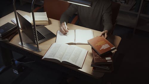 Man Taking Notes From A Book