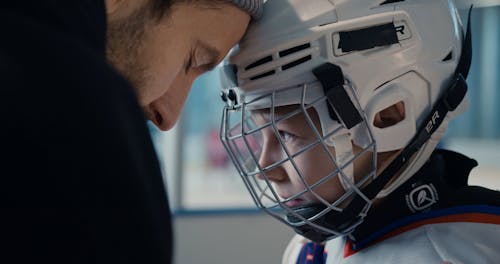 Man and Boy Praying Before Hockey Game