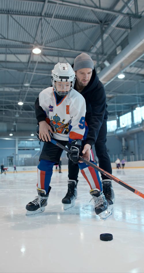 A Man Teaching his Son about Ice Hockey