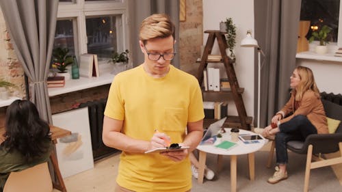 Man Writing on Clipboard at the Office