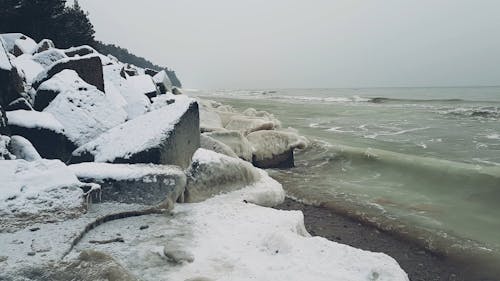 Sea Waves Crashing Upon Icy Rocks