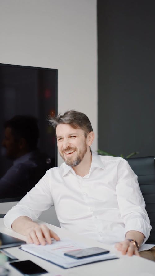 A Man Talking and Smiling in the Office