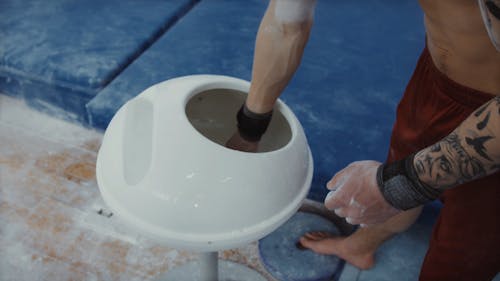 A Man Putting on Chalk on His Hands